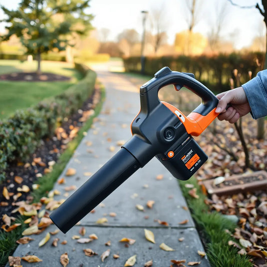Cordless blower gun in hand clearing leaves from a garden pathway