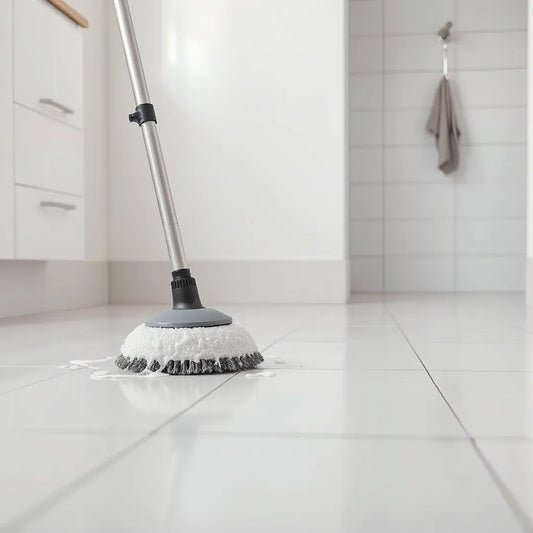 Electric spin scrubber cleaning tile grout on a bathroom floor with spinning brush head